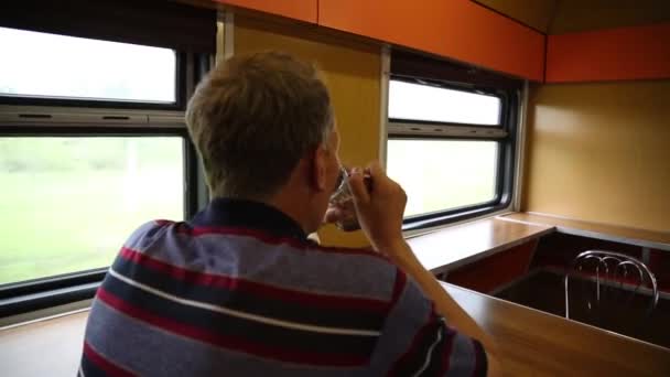 一个男人坐在火车餐厅里 一个40岁50岁的男人正在长途火车上喝茶 — 图库视频影像