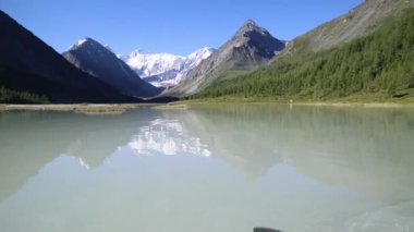 Tekneyi kıyıya yüzüyor. Gölün kıyısında küçük bir tekne kürek tarafından su bendi kapağı.