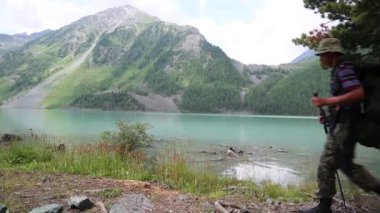 İki turist göl gidin. Erkeklerle birlikte bir sırt çantası dağ Gölü.