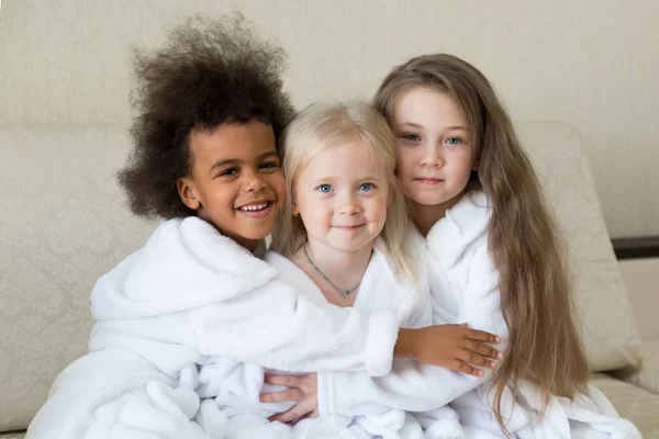 Çocuk farklı dinlerin birbirine sarılmak. Kızlar farklı inançlara sahip Müslüman ve Hıristiyan kadın birlikte mutluyuz.