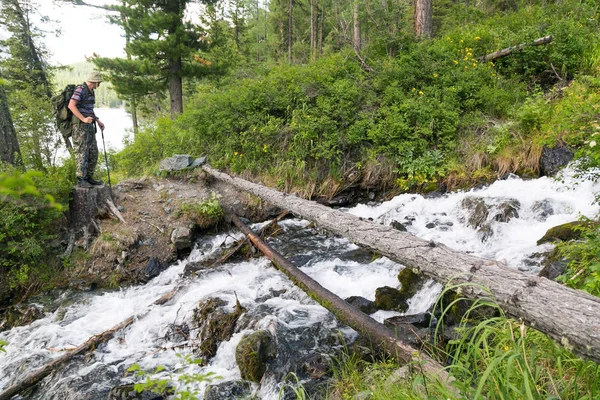 有清澈水的山溪 一个男人的旅行者站在一棵树和一条快速的山溪附近 — 图库照片