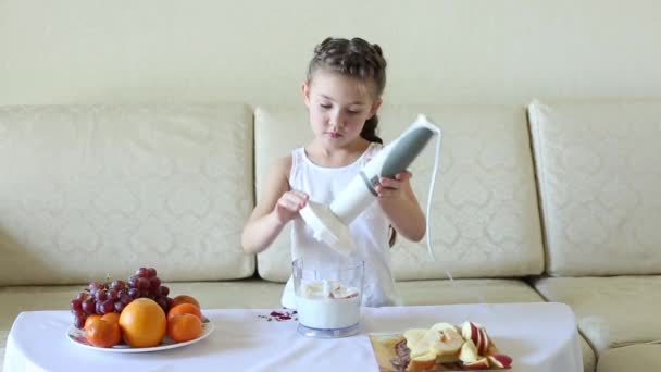 孩子们在搅拌机里准备鸡尾酒 一个小女孩在搅拌机里准备自己的食物 做了美味的水果和牛奶鸡尾酒 — 图库视频影像