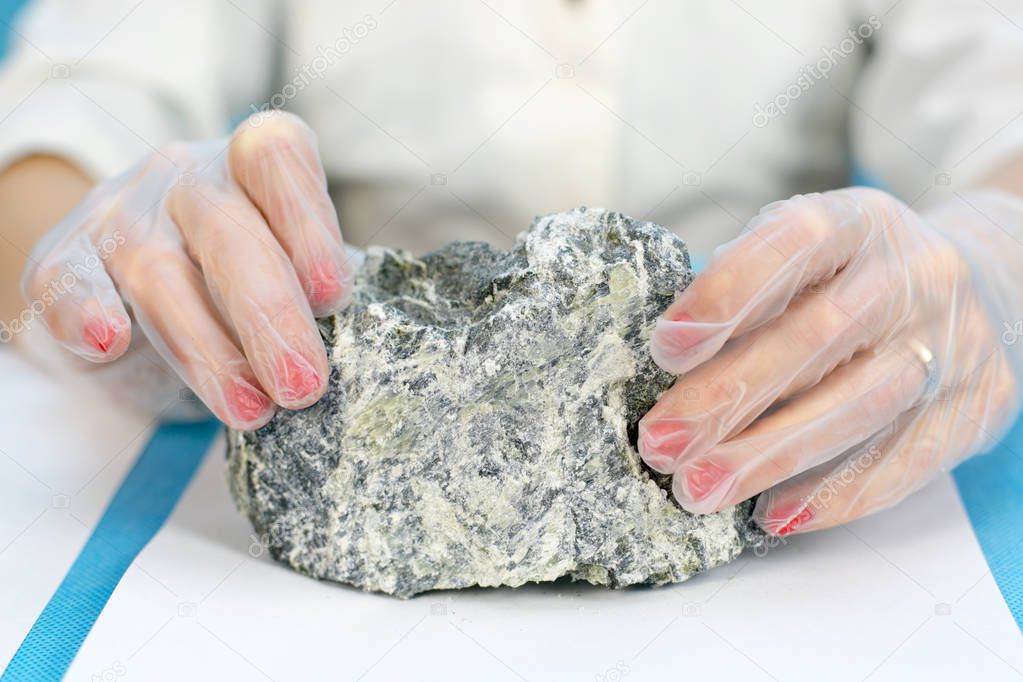 Female hands hold the dangerous mineral asbestos.