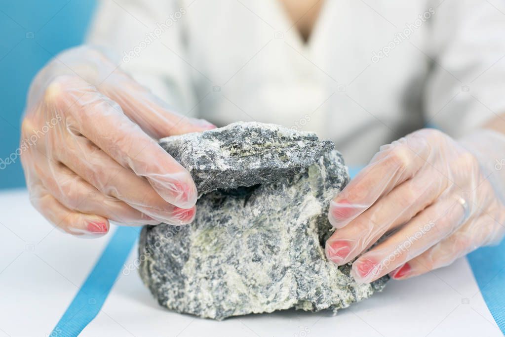 Female hands hold the dangerous mineral asbestos.