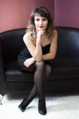 Kız menekşe arka plan üzerinde siyah bir kanepe.