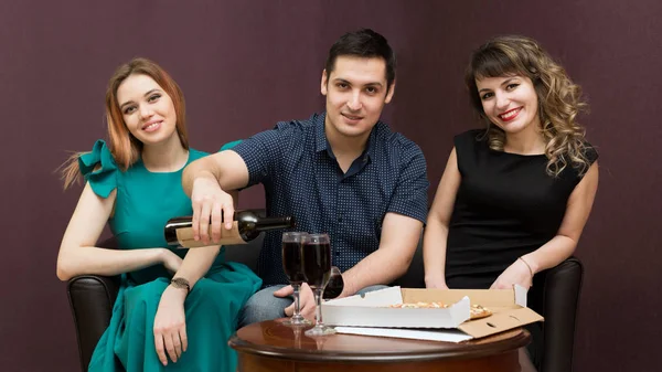 女の子は 楽しさと飲むワイン ピザを食べる男を誘惑します 人の女性党 アルコールの会社で一人の男 — ストック写真