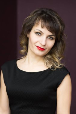 Kıvrılmış saçlı siyah kolsuz elbiseli bir kız.