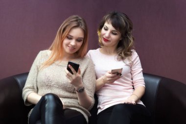 Yakın arkadaş kanepe Birbirinizle konuşmak üzerinde ve Internet üzerinde oturup.