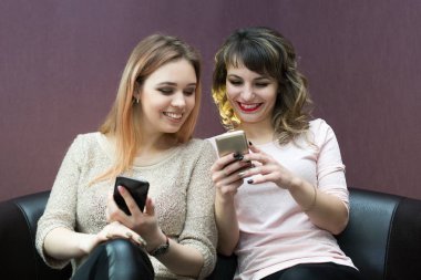 Yakın arkadaş kanepe Birbirinizle konuşmak üzerinde ve Internet üzerinde oturup.