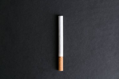 Siyah bir arka plan üzerinde bir filtre ile bir sigara.