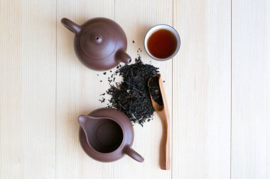 Çay töreni ayarla ve siyah çay ahşap arka plan aromalı. Çay ve siyah çay tabakları masaya serpilir.