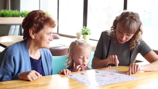 祖母の娘と孫娘のカフェでメニューを見て — ストック動画