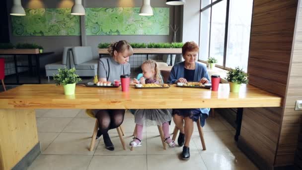 さまざまな年齢の 人の女性のカフェでランチ 祖母の娘と孫娘がレストランで寿司ロール フライド ポテトを食べる — ストック動画