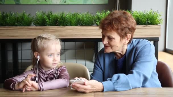 Бабушка Носила Наушники Внучке Послушать Аудио Сказку Пожилая Женщина Отставке — стоковое видео