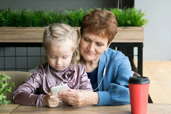 Abuela jubilada y nieta jugando por teléfono . — Foto de Stock