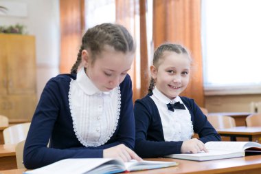 Okul masa başında otururken çocuklar yazmak.