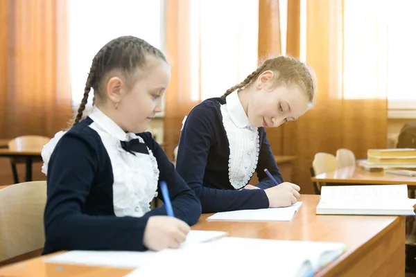 Girl classmate looks into someone else's notebook. — Stock Photo, Image