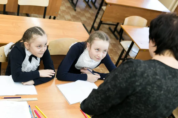 学校女生害怕老师的哭声 十几岁的女孩同学坐在桌旁 恐惧地看着学校老师 — 图库照片