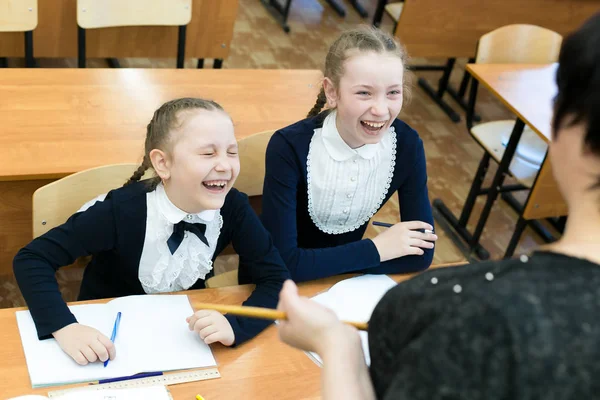女子高生のティーンエイジャーは先生を笑う 二人の女子高生は 彼らの先生のレッスンで笑う — ストック写真