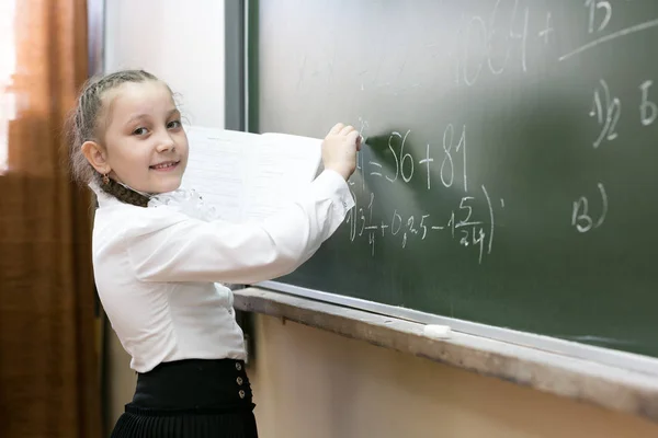 Uma Menina Estudante Ensino Fundamental Escreve Quadro Negro Colegial Segura — Fotografia de Stock