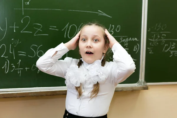 Het schoolmeisje pakte haar hoofd van de spanning. — Stockfoto