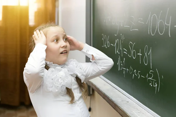 Het schoolmeisje pakte haar hoofd van de spanning. — Stockfoto