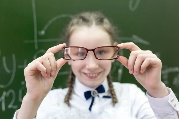その少女はメガネの厚いレンズを通して見る 視力のための大きな厚いメガネを持つ女子高生 大きな面白い目 — ストック写真