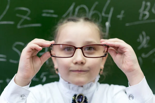 視界大きな面白い目のための大きな厚いメガネを持つ女子高生 少女はメガネの厚いレンズを通して見る — ストック写真