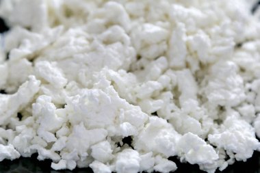 Süt lor makro fotoğrafçılık yakın çekim. Makro shot süzme peynir yararlı ve lezzetli süt ürünü.