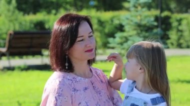 Anne küçük kızı nasiçli bir şekilde yatıştırıyor. Genç bir kadın yavaşça bir yaralı üzgün küçük kız onu neşelendirmek istiyor konuşurken