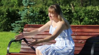 Genç bir kadın kucaklar ve bir park bankında otururken onun küçük kızı öper.,