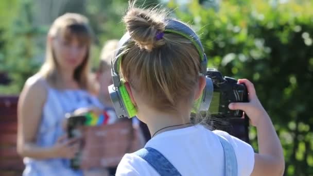 Ein Kleines Mädchen Mit Kopfhörer Und Kamera Filmt Die Handlung — Stockvideo