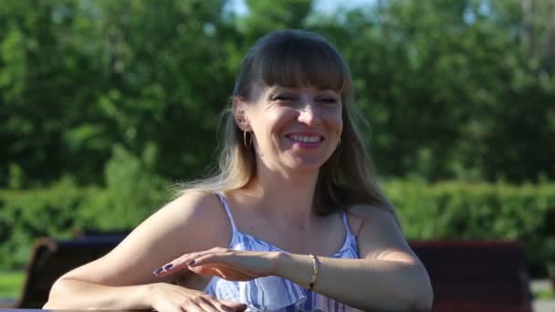 緑を背景に公園の夏晴れた日に白人国籍の女性の35 40歳のクローズアップポートレート — ストック動画