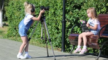 Şehir parkında fotoğraf appart ile çocuklar. 4-5 yaşındaki kızlar televizyon işçileri oynayan bir fotoğraf makinesi video çekim.