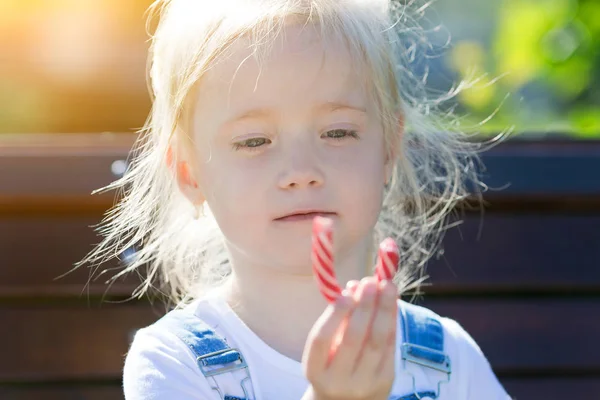 여름 분수의 배경에 자신의 손에 사탕을 가진 아이. — 스톡 사진