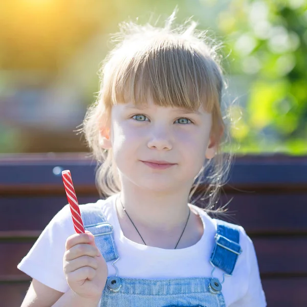 흰색 줄무늬 빨간 사탕을 가진 아이의 초상화. — 스톡 사진