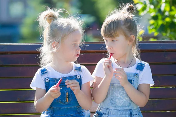 两个女孩在公园里吃糖果. — 图库照片