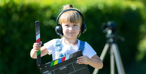 Ein Kleines Mädchen Mit Kopfhörer Und Einem Fernsehgerät Der Hand — Stockfoto