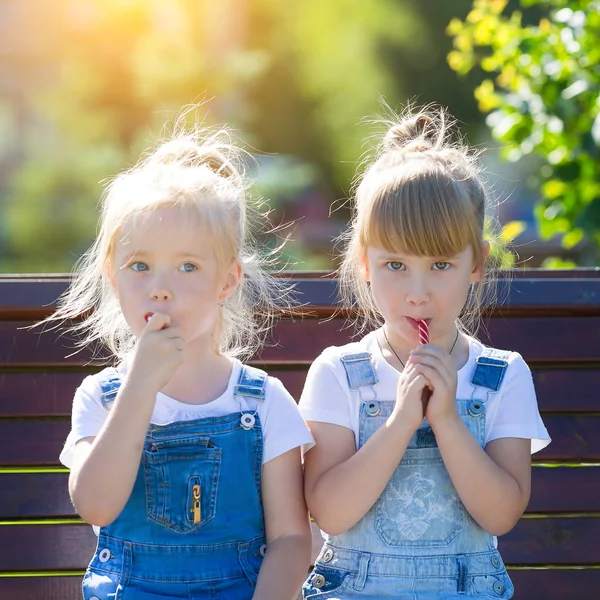 Dos Niñas Años Edad Sientan Banco Parque Rasgan Gran Caramelo —  Fotos de Stock