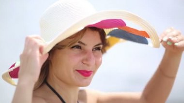 Denizin yakınında geniş alanlarla şapkalı kız. Büyük bir şapka güzel esmer kız denize bakıyor
