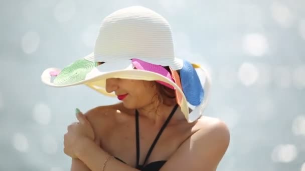 Una Chica Con Sombrero Frota Una Crema Bronceadora Sobre Sus — Vídeos de Stock