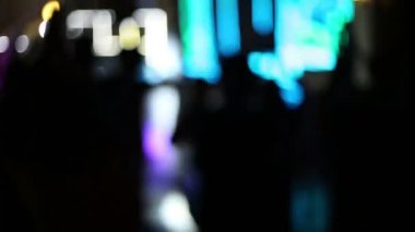 Arka planda parlak ışıklar arasında bir gece kulübünde dans insanların bulanık görüntü. Bir diskoda bir kalabalık, odak yok.