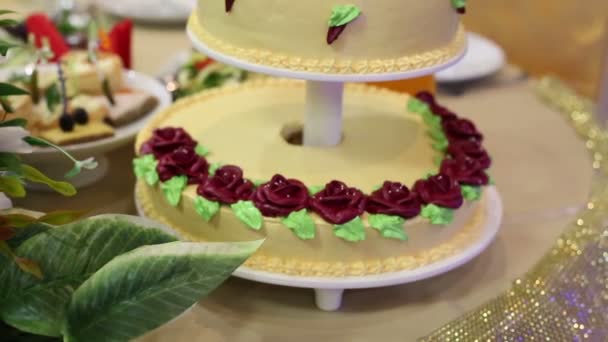 Auf dem Tisch der Braut und des Bräutigams liegt eine schöne große Torte mit drei Rängen. Kuchen aus drei Stockwerken bei einer Hochzeit.