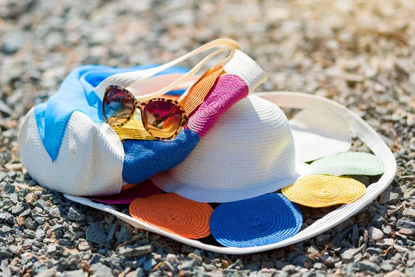 Bolso sombrero de mujer y gafas en la playa . — Foto de Stock