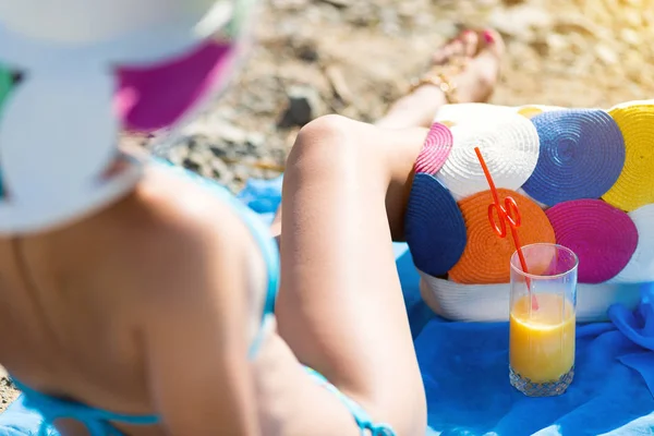 Chica descansando sentada en una toalla en la playa . — Foto de Stock