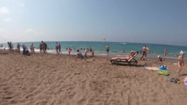 Manavgat, Türkiye 10 Temmuz 2019: Denizde yüzen ilk kişiden video. Bir adam insanlarla sahil boyunca yürür ve suda yüzmeye gider..
