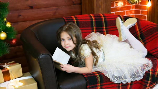 Menina lê um livro com interesse . — Fotografia de Stock