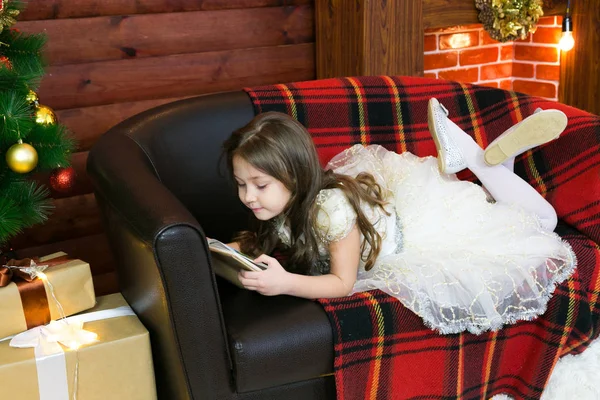 Menina lê um livro com interesse . — Fotografia de Stock