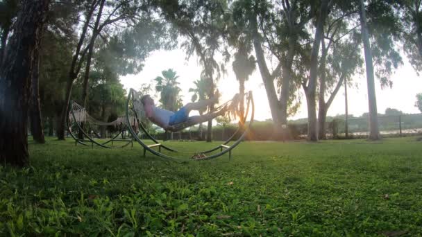 Homem Está Deitado Numa Rede Pôr Sol Homem Caucasiano Descansando — Vídeo de Stock