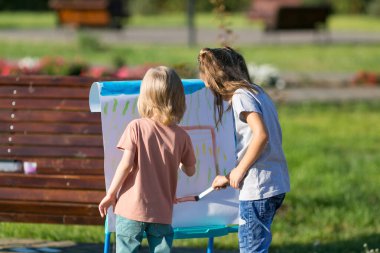 Genç arkadaşlar sokakta bir resim çiziyor.